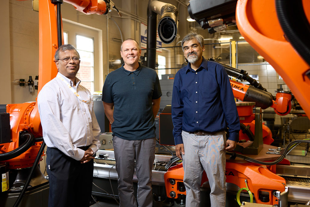Suresh Babu, Tony Schmitz, and Uday Vaidya in front of manufacturing equipment