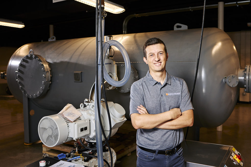 photo of Damiano Baccarella in front of a wind tunnel in his new lab