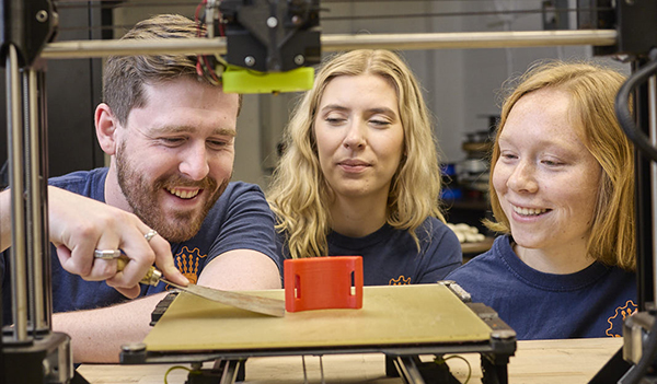 male and two female students at 3d printer