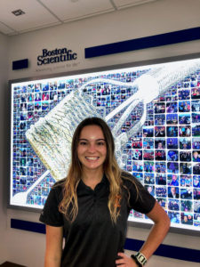 photo of Nicole Beutz standing in front of a digital monitor at Boston Scientific
