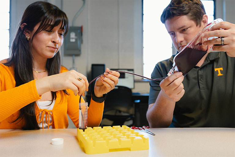 Bryan Good and a student in his lab demonstrate blood flow. 